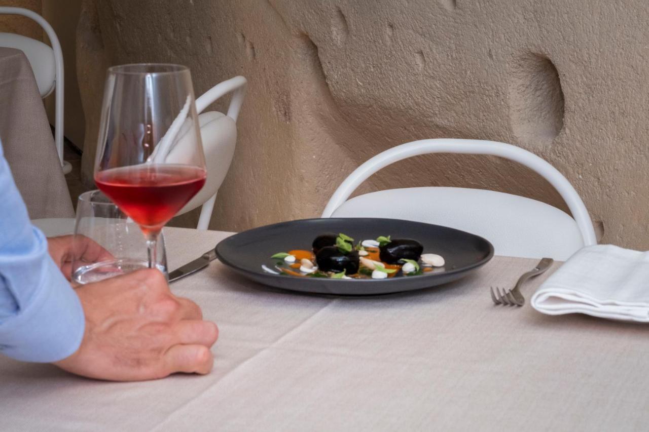 Aquatio Cave Luxury Hotel&SPA Matera Esterno foto A glass of wine and a plate of food